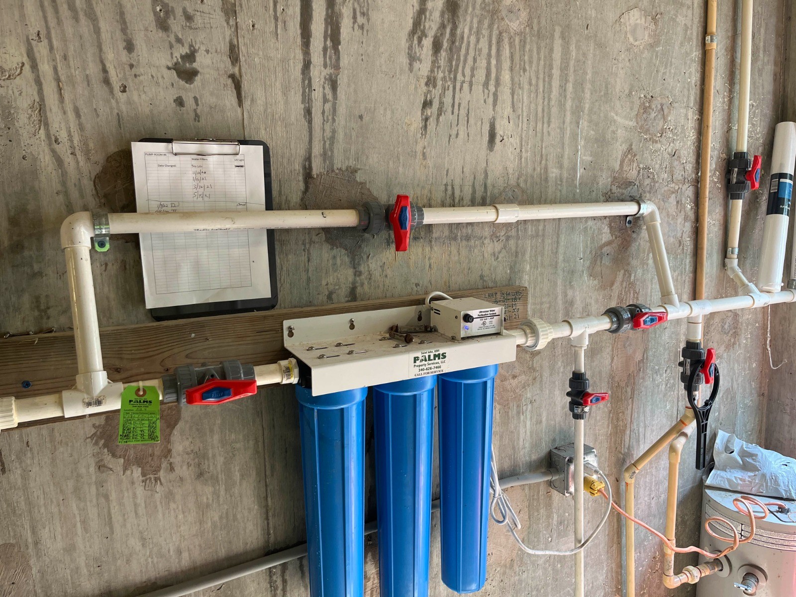 Complete water-filtration installation with filters, valves, and connected plumbing